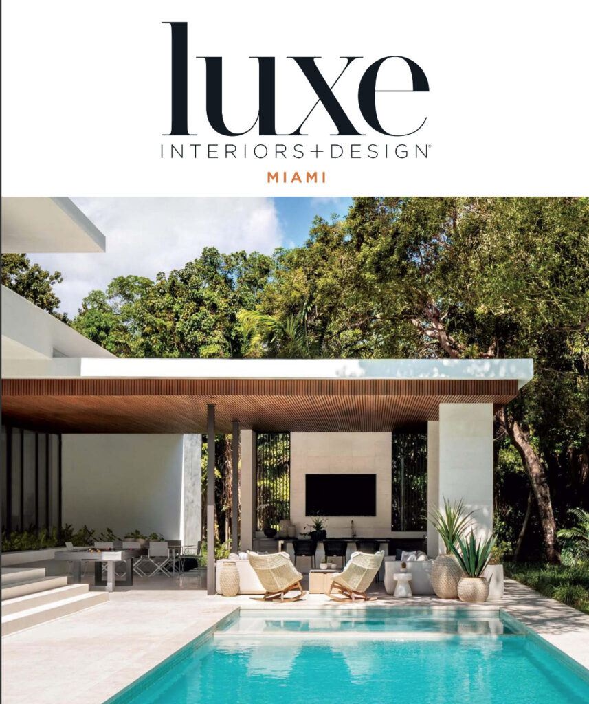 Modern Miami home with pool, outdoor lounge area, and lush subtropical landscaping, featured in Luxe Interiors + Design magazine.