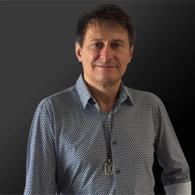 CoFounder & Managing Director Adam Wasilewski in a patterned shirt, emphasizing expertise in custom millwork and integrated design solutions.